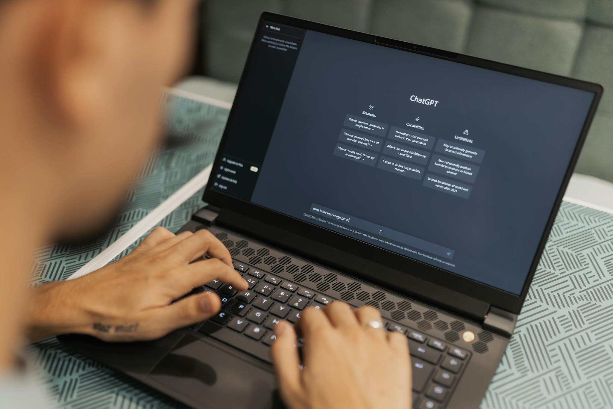 traforma i tuoi dati in risposte Close-up of a person typing on a laptop displaying the ChatGPT interface, emphasizing modern technology use.